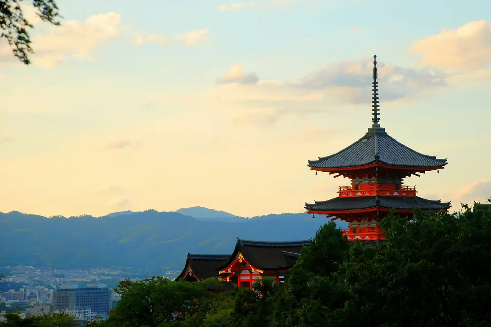 The red pagoda of Kiyomizu-dera glowing at sunset above Kyoto