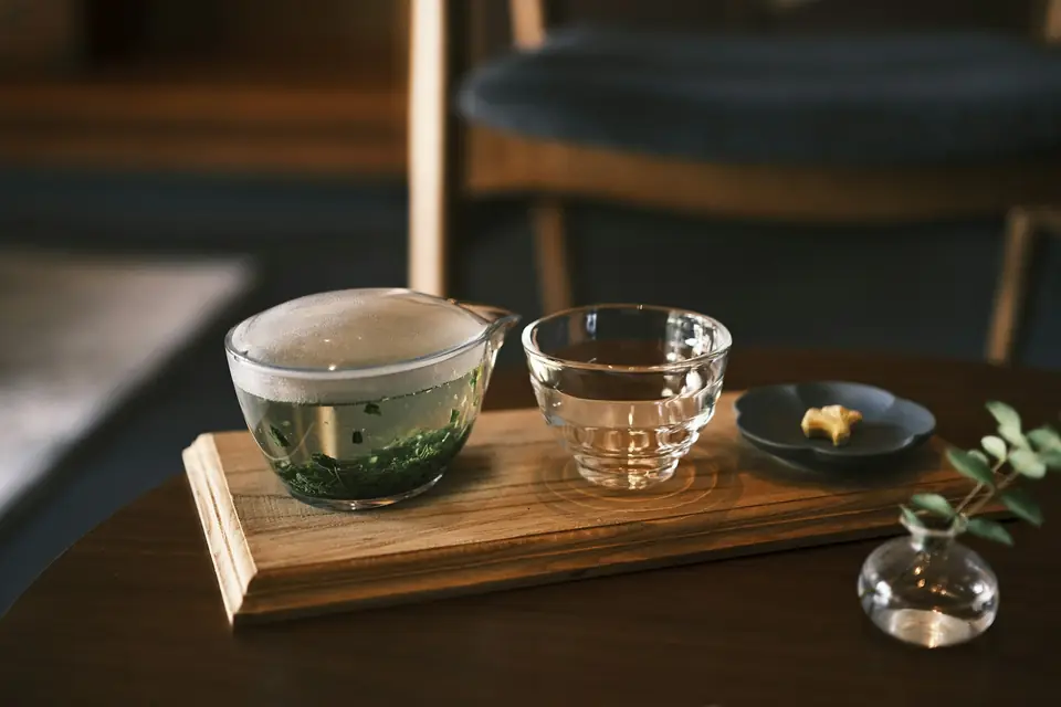 Matcha and a small sweet served on a wooden tray