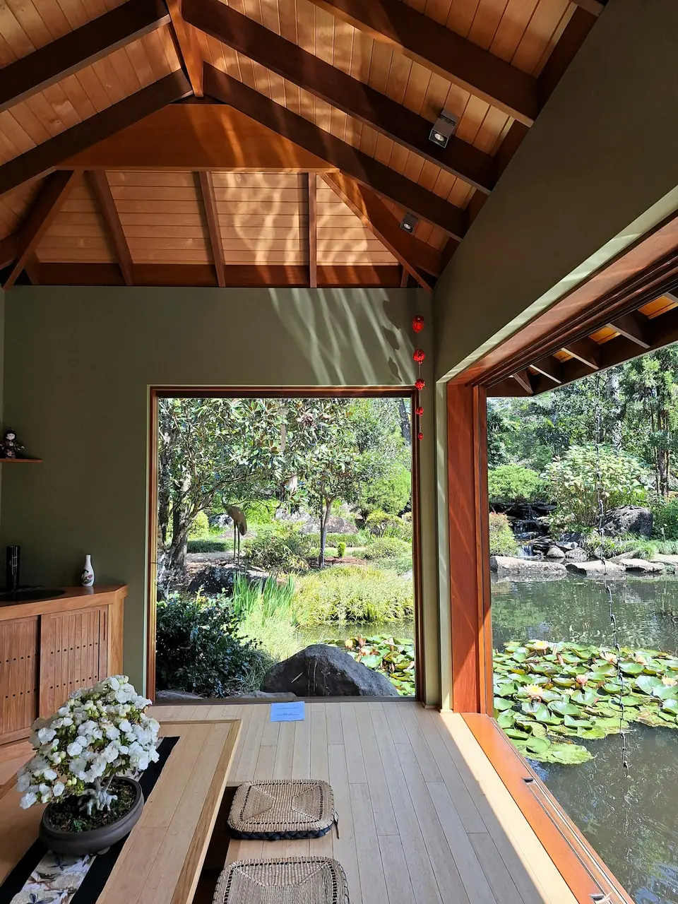 A tea room opening onto a green garden pond