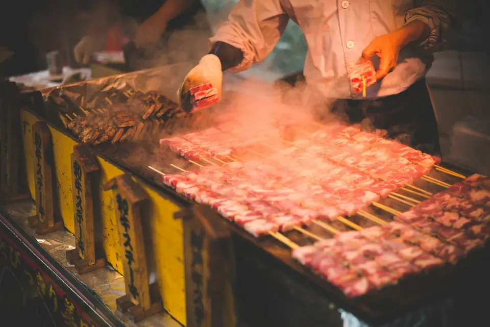 Skewers sizzling over a smoky street-food grill in Osaka